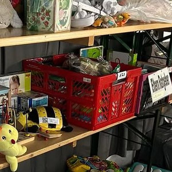 Regal voller Spielsachen, in der Mitte ein roter Klappkorb