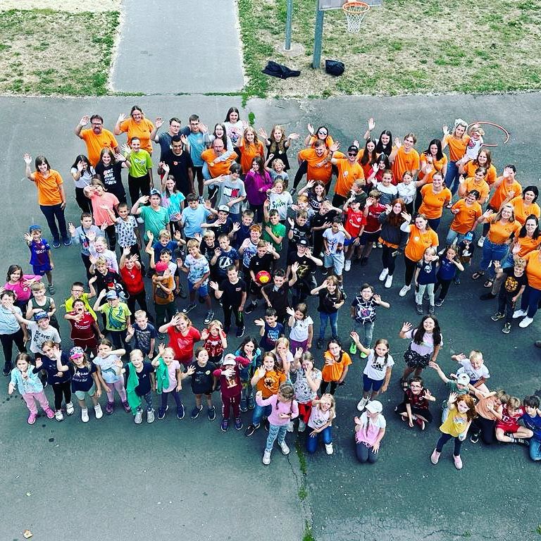 Foto aus der Luft mit winkenden Kindern und Erwachsenen
